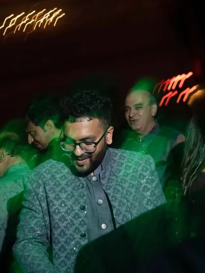 A candid shot of the groom enjoying the after-party, with motion blur capturing the energy of the dance floor.