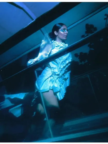 Another image from 'The Last of Them,' using blue lighting and a low angle to create a futuristic mood. The reflective material of the garment catches the light in an interesting way.