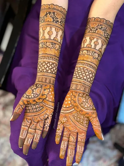 A full-coverage bridal design with repeating bands of intricate patterns. The symmetry and consistency in the design create a mesmerizing and elegant look.