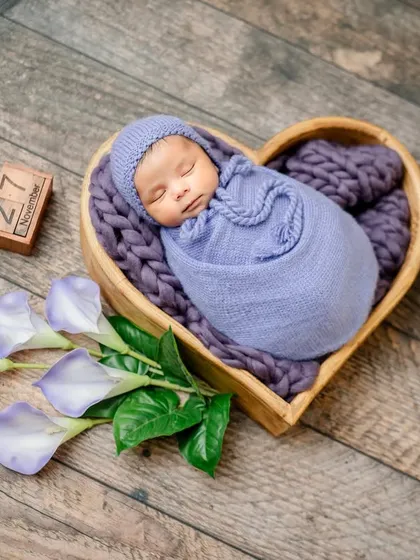 A wider angle of the heart-shaped basket setup, showing the purple tulips that complement the baby's wrap.