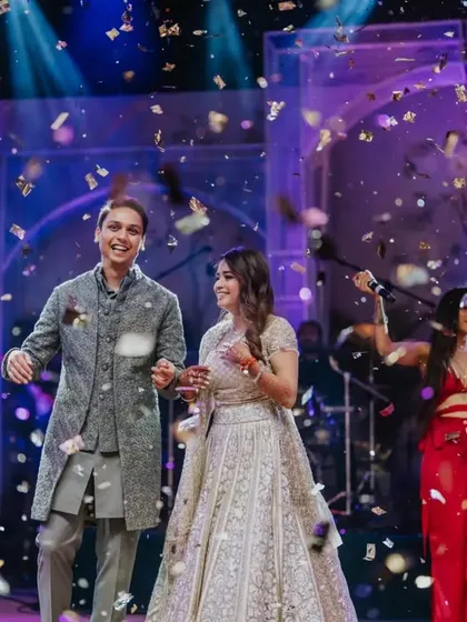 A shower of confetti and sparks rains down on the happy couple. This photo captures the peak energy of their Sangeet performance, a moment of pure celebration and happiness on a grand stage.