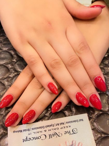 A classic set of almond-shaped nails in a bright, glossy red. This timeless and confident look never goes out of style.