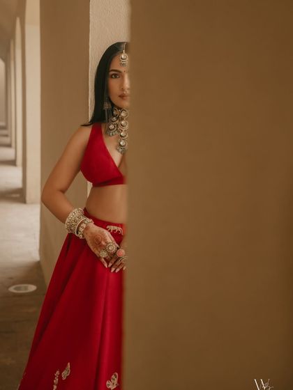 An artistic shot highlighting the intricate details of the bride's jewelry and the flawless finish of her makeup.