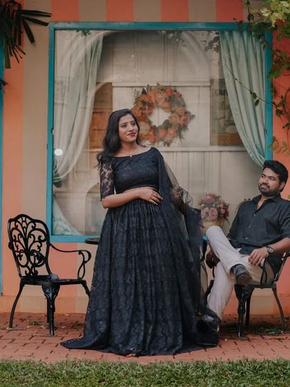 A relaxed and stylish shot of a couple sitting in front of a charming, colorful house facade.