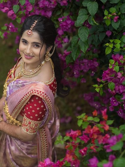 Ranjitha looks dazzling in a lavender Kanchivaram saree paired with a contrasting red raw silk blouse. I added a custom hand-embroidered border to the saree to elevate the entire look.