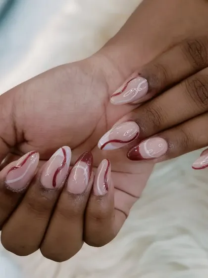 Another view of the abstract red and white swirl design on almond nails.
