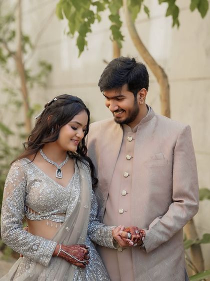 A sweet moment between the newly engaged couple. The bride is wearing a soft, romantic makeup look with loose waves, perfect for her outdoor ring ceremony in Ahmedabad.