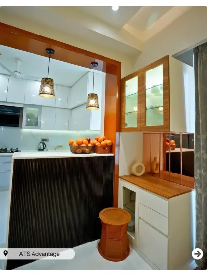 This design features a stylish partition that separates the kitchen and dining areas while maintaining an open feel. The hanging lights add a decorative touch.