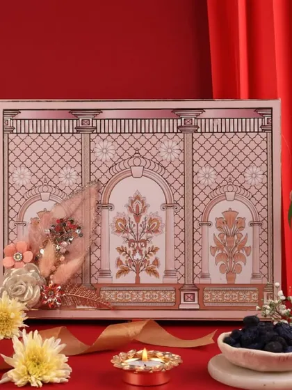 A classic Diwali hamper setup with a rich red backdrop. I used elegant candelabras, fresh flowers, and a lit diya to frame the ornate gift box, making it the hero of the shot.