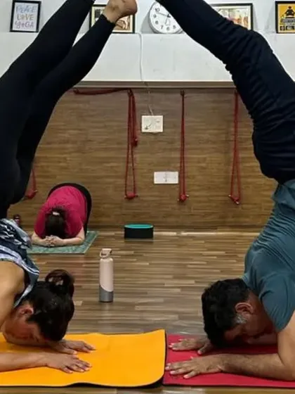 The beauty of partner yoga lies in creating shapes together. This synchronized headstand shows the focus and connection shared between students in our studio.