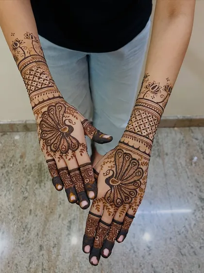 The peacock is a timeless symbol of grace and beauty in mehendi art. Here, I've made it the centerpiece of the design, with intricate feather details on the palm and geometric patterns extending up the wrist.