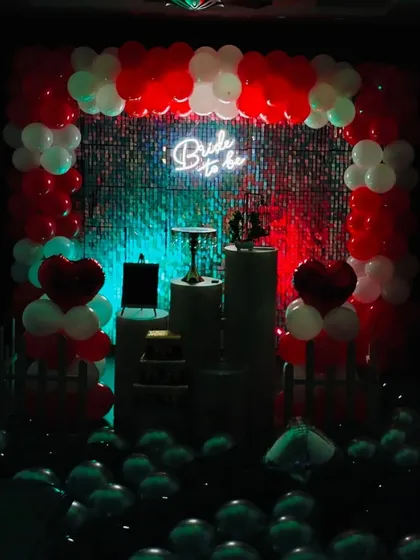 A dramatic, low-light photo of the pre-wedding party decor. The neon sign and colored lights create a perfect backdrop for photos and celebrating with your bridal party.