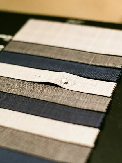A swatch book showcasing a range of high-quality fabrics. This is where clients begin to visualize their custom suit, choosing from an array of colors and textures.