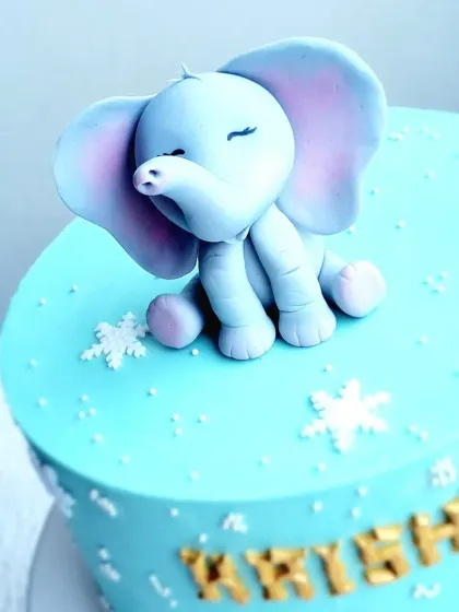 A close-up of the sweet, sleeping baby elephant topper, showing the delicate shading on the ears.