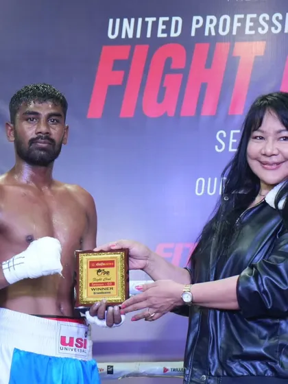A victorious fighter being awarded his prize. We celebrate every win as a step forward in their professional career.