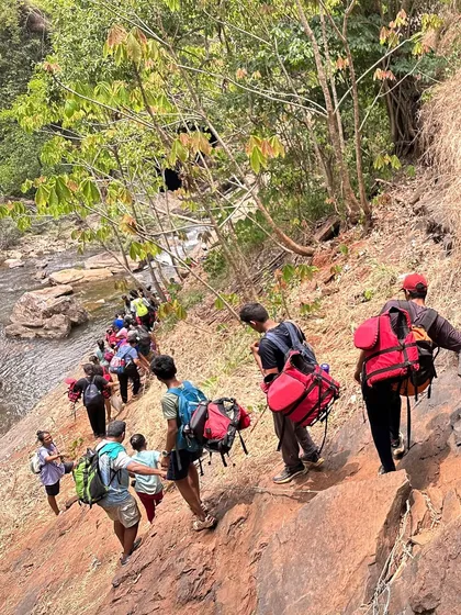 Participants carefully trek down a steep path to reach a secluded stream in the forests of Uttar Kannada.