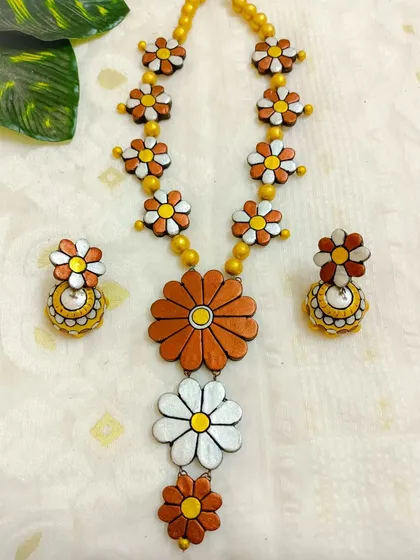 A warm, earthy version of the long floral necklace in brown and white. This color combination is subtle yet elegant, perfect for a sophisticated ethnic look.