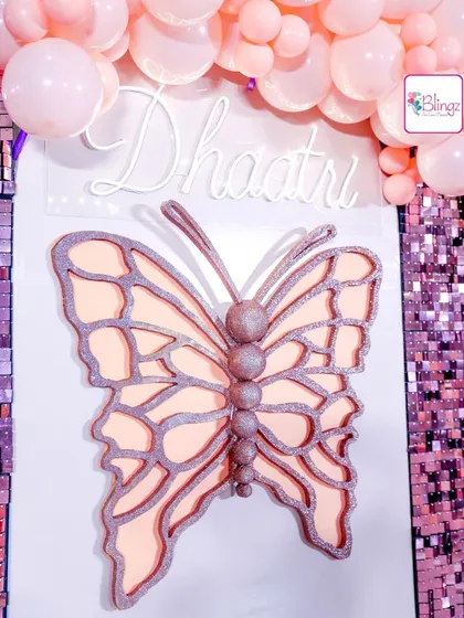 A custom-designed butterfly centerpiece with a neon name sign. This element served as a beautiful backdrop for the dessert table, combining personalized details with a sparkling sequin wall.