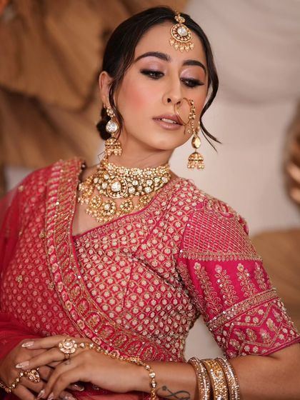 A complete bridal look featuring a heavy, gold-plated Kundan necklace, haath phool, and maang tikka, all available for rent.