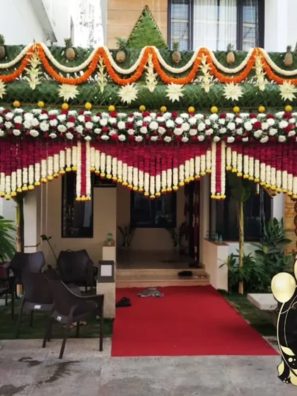 A grand entrance for a traditional South Indian wedding. I constructed this welcome arch using a classic design with pillars made of polished coconuts, intricate floral thoranams, and a roof woven from fresh coconut leaves.