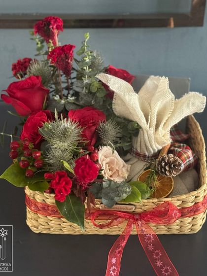 This festive basket shows how mood defines an arrangement. The use of red, pinecones, and plaid ribbon instantly creates a cozy, holiday feeling.