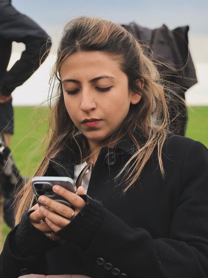 A candid shot of me, likely coordinating details and schedules on my phone. A stylist's work involves constant communication to ensure everything runs smoothly on set.