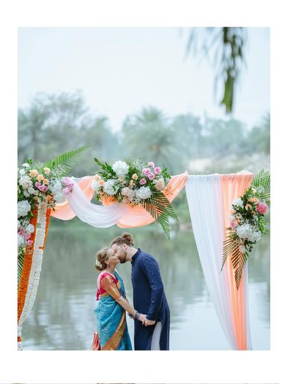 A romantic kiss under a beautiful floral wedding arch by the water. This is the epitome of a fairytale pre-wedding photograph, full of romance and beauty.