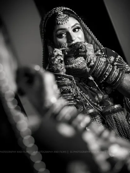 A classic black and white bridal portrait. This timeless style emphasizes emotion and detail, focusing on the bride's expression and the intricate mehndi on her hands.