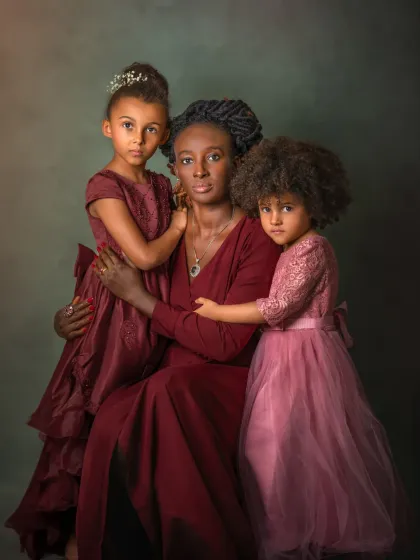 Motherhood is a masterpiece of emotions, and this portrait aims to capture its beautiful complexity. Here, a mother's protective embrace and her daughters' trusting gazes create a powerful, loving tableau reminiscent of a classic painting. It’s a celebration of the unbreakable bond between a mother and her children.