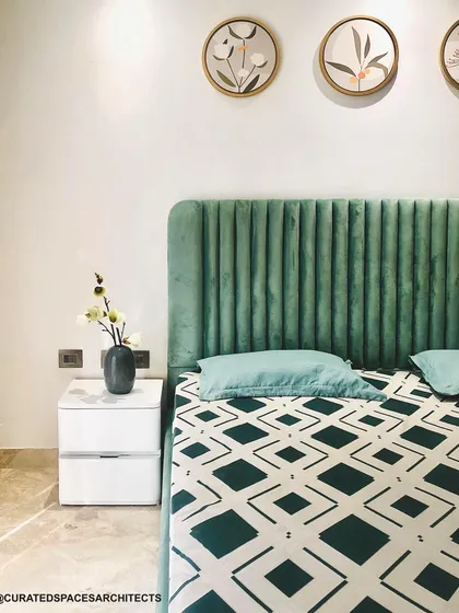 This simple yet elegant bedroom is designed in a soothing olive green. The vertically paneled headboard adds texture, while the minimalist nightstand keeps the look clean and uncluttered.