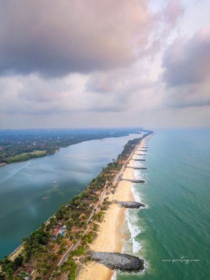 A vertical aerial shot of Mattu Beach, showing the line of sea barriers protecting the narrow strip of land between the river and the ocean.