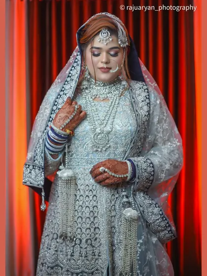 A close-up portrait focusing on the bride's stunning jewelry and the detailed embroidery of her dress. Her serene expression adds to the elegance of the photo.