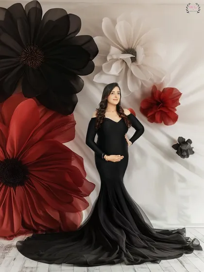 A portrait from the same session, this time against a backdrop of giant paper flowers, adding a touch of artistic flair.