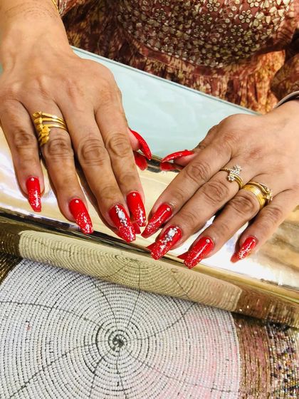 A different angle showing the detailed stone and glitter work on these stunning red bridal nails.