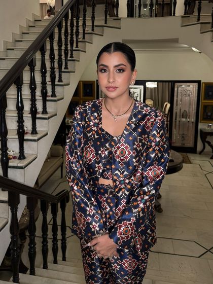 A full view of this chic and festive look. The bronze makeup complements her printed outfit perfectly, creating a sophisticated and modern Diwali style.