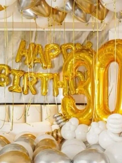 A close-up of the large '30' and 'Happy Birthday' foil balloons, which are the centerpiece of this milestone birthday decoration.