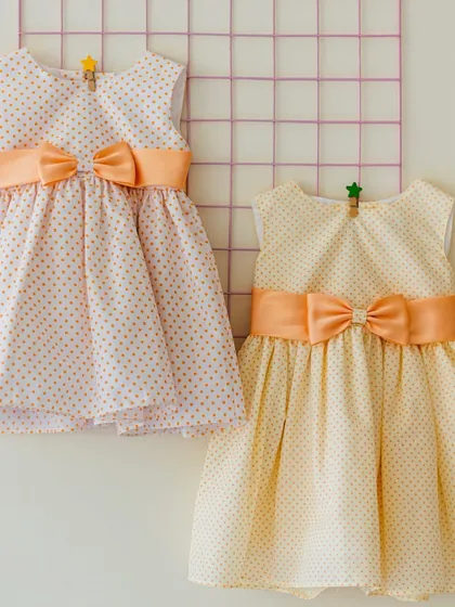 Two sweet polka dot dresses in peach and yellow. Using the same fabric in different colors is a wonderful way to create a matching set that still feels unique.