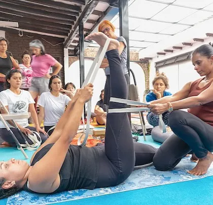 Teaching is a process of mutual learning. During a workshop in Bogota, Colombia, I guide a student in Supta Padangusthasana using a strap. This hands-on adjustment helps her find greater length and stability, showcasing the personalized and supportive nature of my sessions, no matter where in the world we practice.