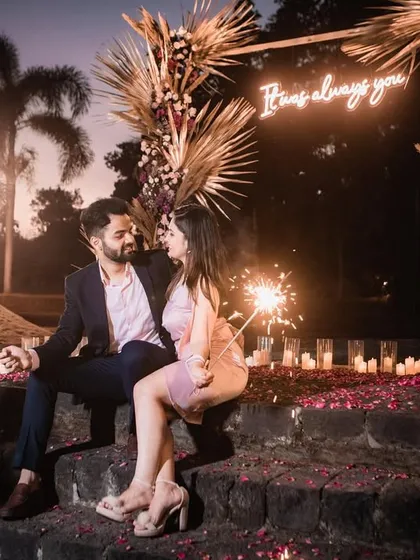 The couple sharing a quiet moment with sparklers, surrounded by the romantic ambiance of our custom proposal setup at dusk.