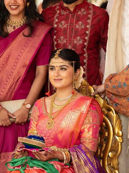 A beautiful shot of the bride surrounded by family. Her look is classic and timeless, ensuring she stands out while also looking harmonious with the traditional setting.