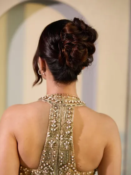 The back view of the Bridgerton-inspired updo. It's a beautifully intricate but soft bun that looks sophisticated and romantic, perfectly matching the theme of the evening.