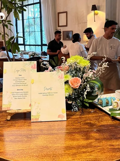 A beautifully set table at a restaurant event, with custom menus and a fresh floral centerpiece, ready to welcome guests for a celebratory lunch.