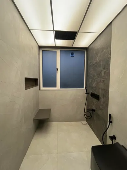 A bathroom should be a personal oasis. In this Sanpada project, we used large format tiles, a backlit ceiling, and matte black fixtures to achieve a clean, minimalist, and spa-like feel.
