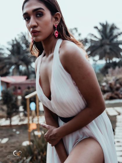 A close-up shot that captures her intense gaze and the beautiful details of her outfit. The outdoor lighting is soft and flattering.