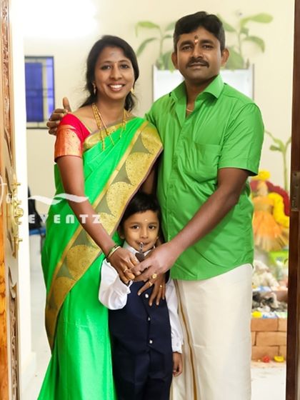 A housewarming ceremony is a major family milestone, and we are there to document it. This family portrait captures the pride and happiness of a family in their new home, framed by traditional floral decorations.