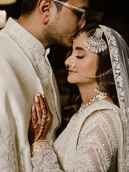 A tender forehead kiss is a promise of protection and deep affection. I captured this serene moment during a Nikah ceremony, highlighting the elegance of the couple's coordinated white attire and the profound emotion of their union. It’s these quiet acts of love that create the most powerful memories.