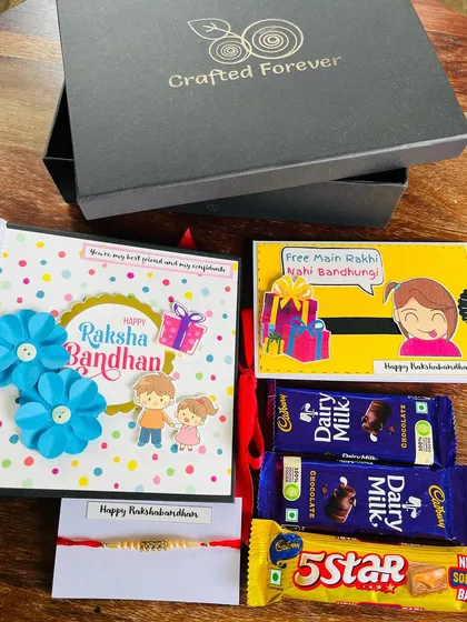 Our Raksha Bandhan hamper is more than just a gift; it's a complete celebration in a box. This one features a handmade photo album, a quirky card, a rakhi, and chocolates, all beautifully arranged. It’s the perfect way to tell your sibling they're special.