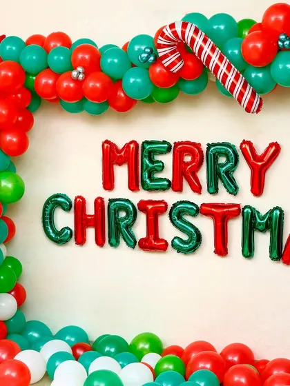 Here is another view of the classic Christmas wall decoration. The organic balloon arch is constructed with red, green, and white balloons, accented with silver baubles, a candy cane, and star-shaped foils for extra sparkle.