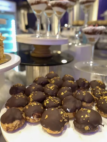 Golden-dusted profiteroles, filled with cream and dipped in rich chocolate. A classic French pastry, served with a touch of glamour.