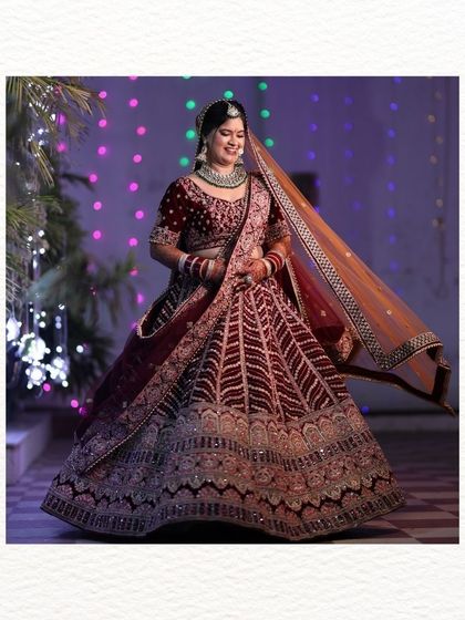A beautiful, happy shot of the bride twirling in her wedding lehenga. The bokeh from the background lights adds a magical feel to this joyful and candid moment.